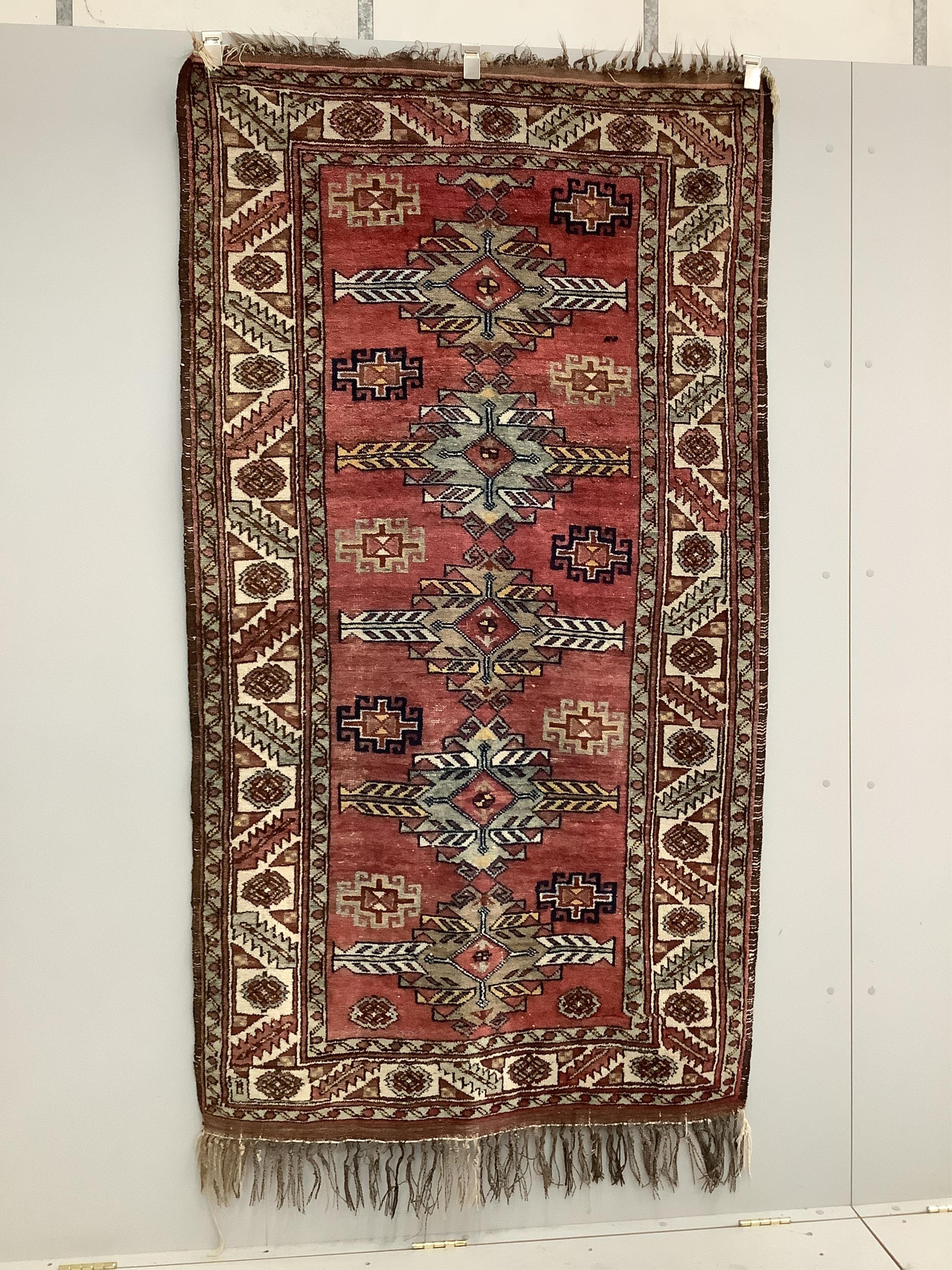 A Caucasian style red ground rug, 210 x 120cm. Condition - fair